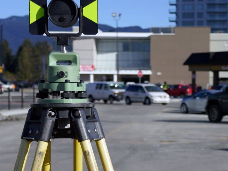 ALTA Survey Commercial Property Vestavia Hills Alabama - Vestavia Hills Land Surveying Theodolite surveying instrument on a tripod in a parking lot with a building in the background.